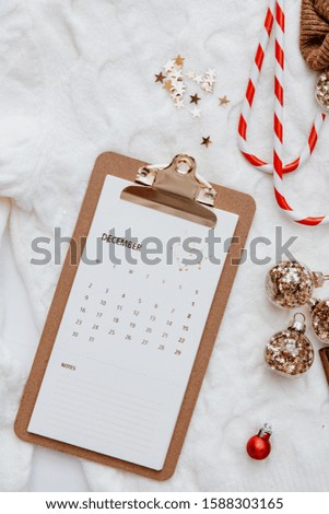 Christmas calendar background with decorations on white bed, top view, flat lay 