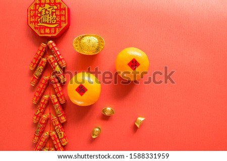 Chinese firecrackers and Chinese gold ingots (foreign meaning blessing, prosperity, fortune, spring，auspicious) and red envelopes and decorated with fresh oranges on Red Paper background
