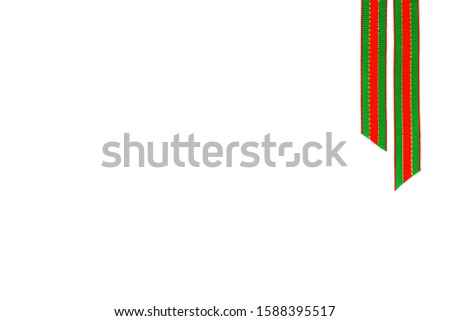 Two stripes of festive red, green, gold ribbon on top right corner isolated on white background.  Concept for holidays