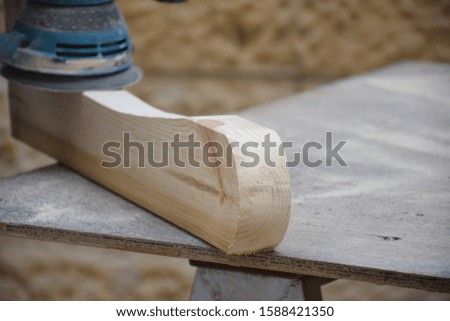 man using sending and polishing machine to polish wood, wooden pine board carpetnry, woodworking workplace, working bench with piece of wood (wood block) on top of it,  professional electric machine. Royalty-Free Stock Photo #1588421350