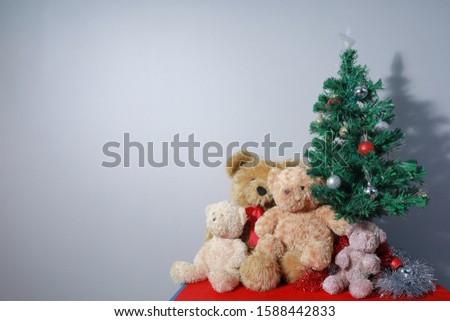Four teddy bear family with christmas tree. Copy space on gray background for christmas festival.