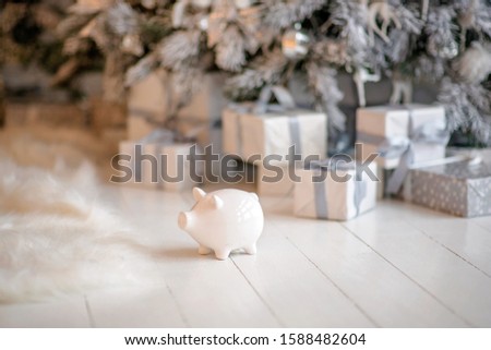 piggy bank with 100 dollars banknote in festive New Year atmosphere of scenery. Magical bokeh with Christmas tree and bright lights.