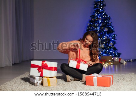 beautiful women with Christmas gifts at the Christmas tree for the new year