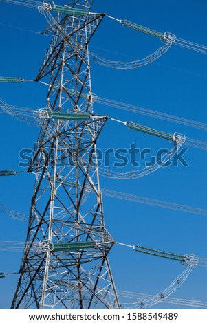 High voltage electric energy transmission power lines with blue sky background  outdoors 
