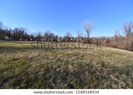 A wide open field in Kansas City, Missouri. Picture taken on a cold day in December. The area is pretty dry and the grass is turning yellow and brown.