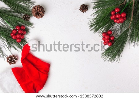 Christmas background with fir and santa hat on white background. Flat lay. Copy space. Mockup.