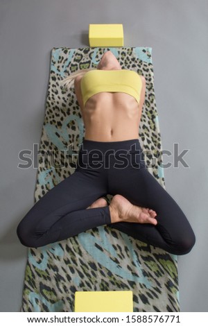Top view of young blonde female in yoga Fish pose
