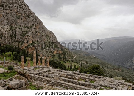 The landscape of ancient Delphi in Greece with Temple Apollo and cloudy weather in the background