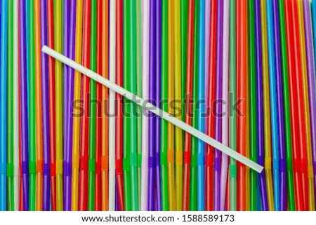 Drinking straws. Abstract background with many multi colored plastic tubules for juice or cocktail, single-use disposable. Top flat view. Close-up.