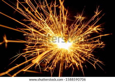 Sparkling sparkler on a black background. New Year theme.