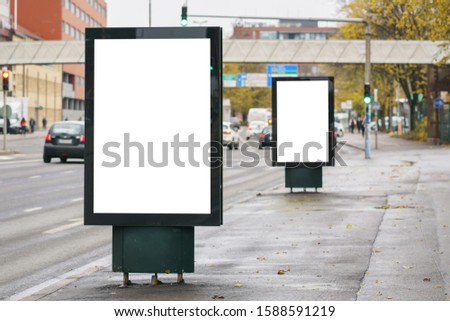 Two blank street billboards with white clipping path around advertising display. Vertical outdoor lightbox.