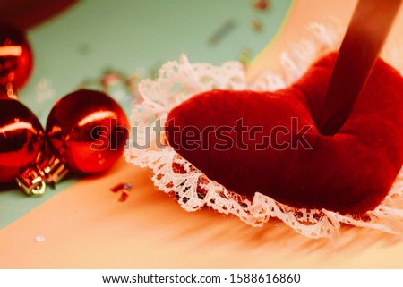 Pictures of love.Toy heart with knife, Hit in the heart. Heartbreaking concept. Sad love story. Valentines day