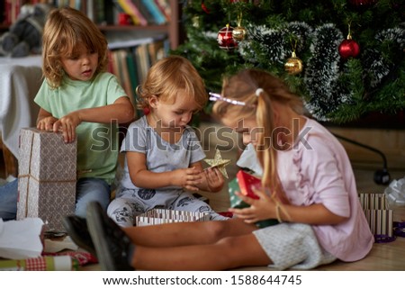 Open Presents On Christmas Morning.Happy Children opening Xmas presents.