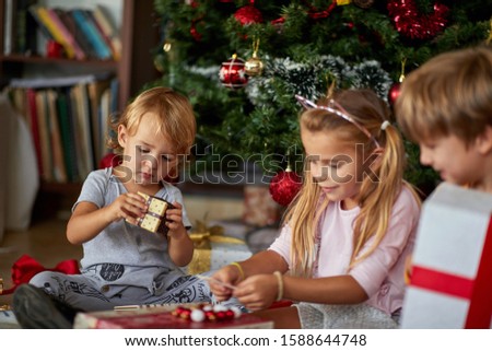 Boy  opening Christmas gift.Surprised little children unpack Christmas gift box