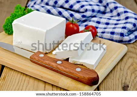 Feta cheese, knife, parsley, tomatoes, napkin on a wooden board Royalty-Free Stock Photo #158864705