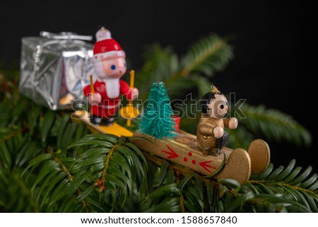 Christmas decorations on the green tree. Tinsels hung on a spruce twig. Dark background.