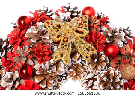 Christmas wreath of red and brown pine cones with golden bow, background on a new year theme close up.