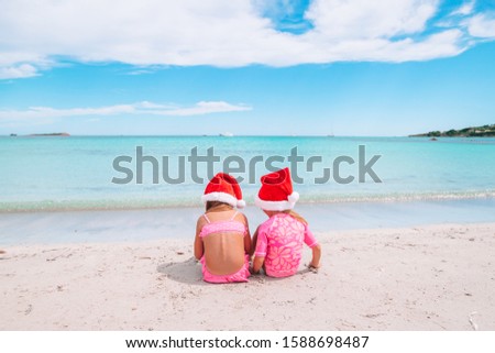 Adorable little girls on Christmas on the beach