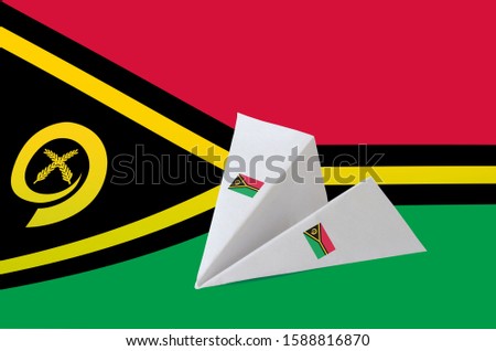 Vanuatu flag depicted on paper origami airplane. Handmade arts concept