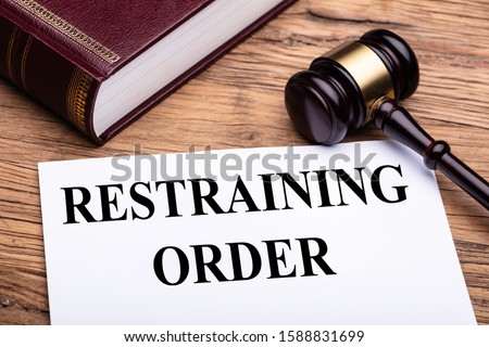 Elevated View Of Document With Restraining Order Title Near Judge Gavel And Law Book Royalty-Free Stock Photo #1588831699