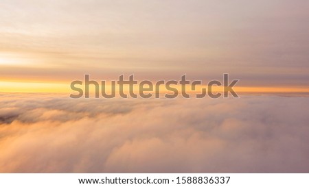Aerial view White clouds in blue sky. Top. View from drone. Aerial bird's eye view. Aerial top cloudscape. Texture of clouds. View from above. Sunrise or sunset over clouds