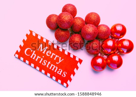 banner on pink background surrounded by red balloons on which he writes merry christmas