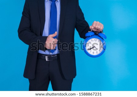 businessman with an alarm clock and doing the ok symbol with his finger