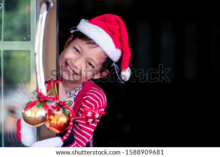 Asian smiling beautiful girl behind door at home.Christmas or X-mas concept