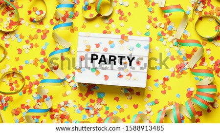 party celebration flat lay with confetti streamers and text on lightbox