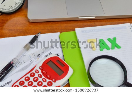 Alphabets with a TAX word on wooden desk. Business concept. Selective focus.