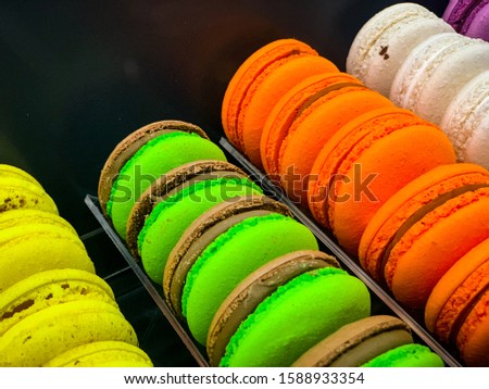 Colorful rainbow macaroons, french bisquits in a row on the dark background for coockbook, menu, logo, postcard, top view.
