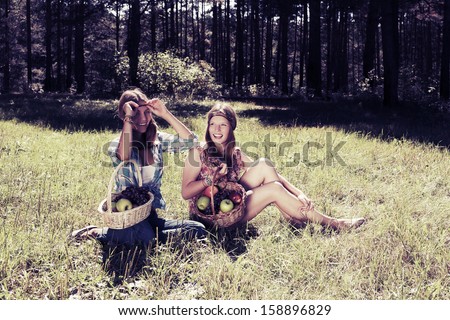 Happy young girls with a fruit basket outdoor