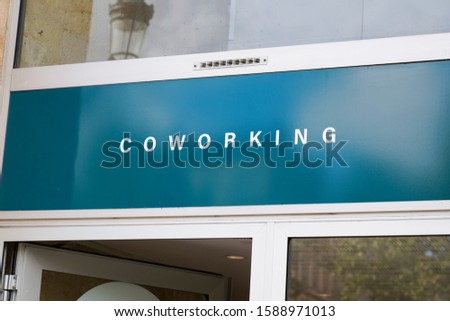 Coworking space sign on wall board outside building in city 