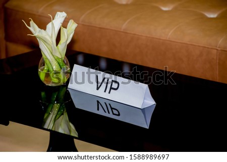 VIP sign on reception table decoration with flower vase.