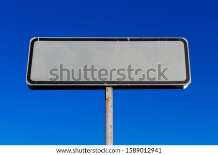 a small white road sign mockup on blue sky background