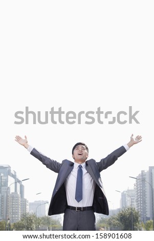 Young businessman with arms raised