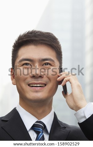 Young businessman smiling and talking on smart phone