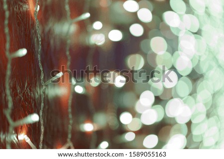 Photography of New Year lights on the city street with defocused background in night. Christmas mood, festive atmosphere. Suitable as template and background for postcards, greeting cards.