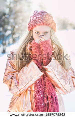 A closeup shot of blonde female warming up her hands on a cold winter day