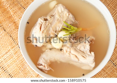 Chicken bone stock soup in bowl on mat