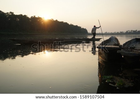Fisherman croosjng the Rapti river ,Chitwan  National Park Nepal