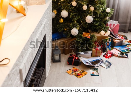 book together near Christmas tree in front of fireplace