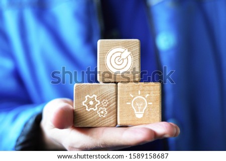 Business concept growth goal, businessman hand arranging wood block with icon business strategy and idea action plan.