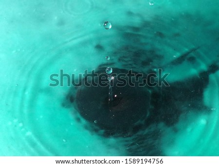 a drop of liquid falls on the surface of the water