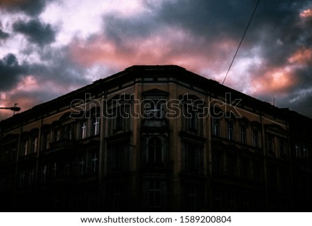 A low angle shot of a concrete building under the beautiful storm clouds