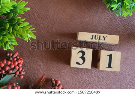 July 31. Number cube in natural concept on leather for the background