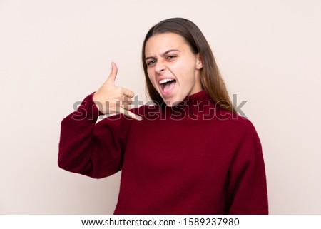 Teenager girl over isolated background making phone gesture