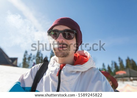 man in sunglasses on a ski slope. frosty sunny day. Guy exhales steam