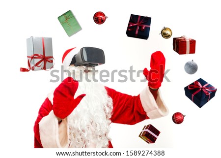 Christmas. Santa Claus in black virtual reality glasses makes gestures with his hands. Surprise, emotion. New technology. Isolated on white background.