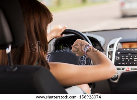 transportation and vehicle concept - woman driving a car and looking at watch Royalty-Free Stock Photo #158928074